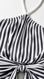 Close-up detail of halter neckline and knotted strap on striped dress