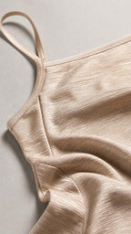 Close up fabric and strap detail of champagne dress