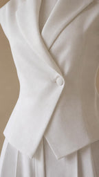 Close-up of lapel collar and single button on white vest