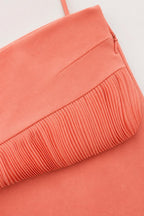 Close-up detail of pleated ruffle hem and side zipper on coral skirt
