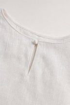 Close-up detail of white dress neckline with button closure
