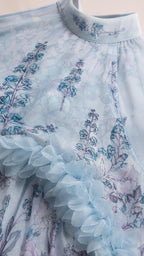 Close-up detail of high neckline and textured ruffles on light blue dress