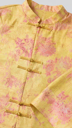 Close-up detail of yellow brocade fabric and knot buttons