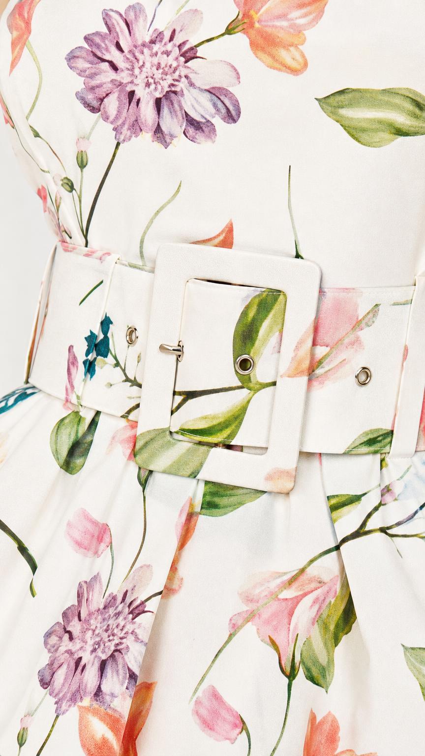 Close up of floral pattern and belt buckle detail on romper