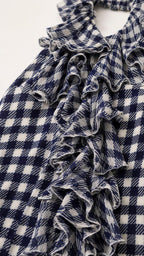 Close-up detail of cascading ruffles on navy gingham fabric