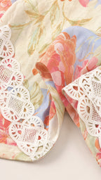 Close-up detail of floral fabric pattern and white crochet lace trim