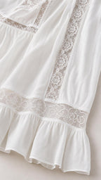 Close-up detail of lace trim and ruffle hem on white dress