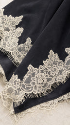 Close-up of black fabric and detailed lace hem