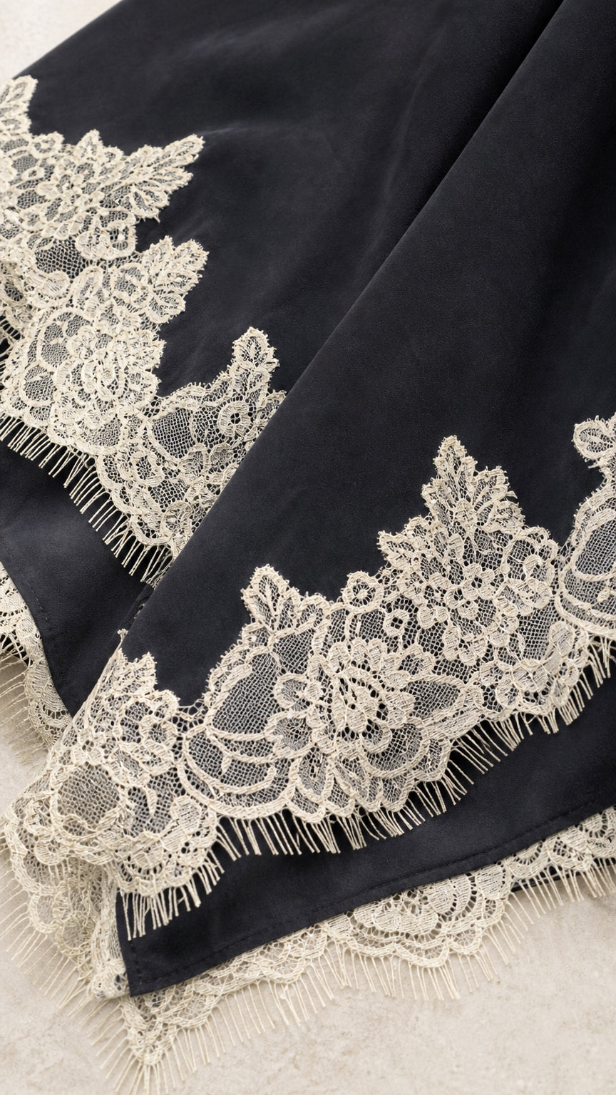 Close-up of black fabric and detailed lace hem