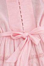 Close-up of bodice, buttons, and waist tie on pink dress
