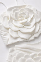 Close-up flat lay detail of white 3D fabric rose appliqué on top and skirt