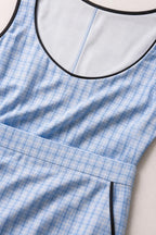 Close-up detail of scoop neckline and plaid fabric