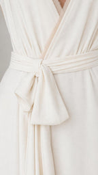 Close-up detail of the waist tie and bow on the white dress