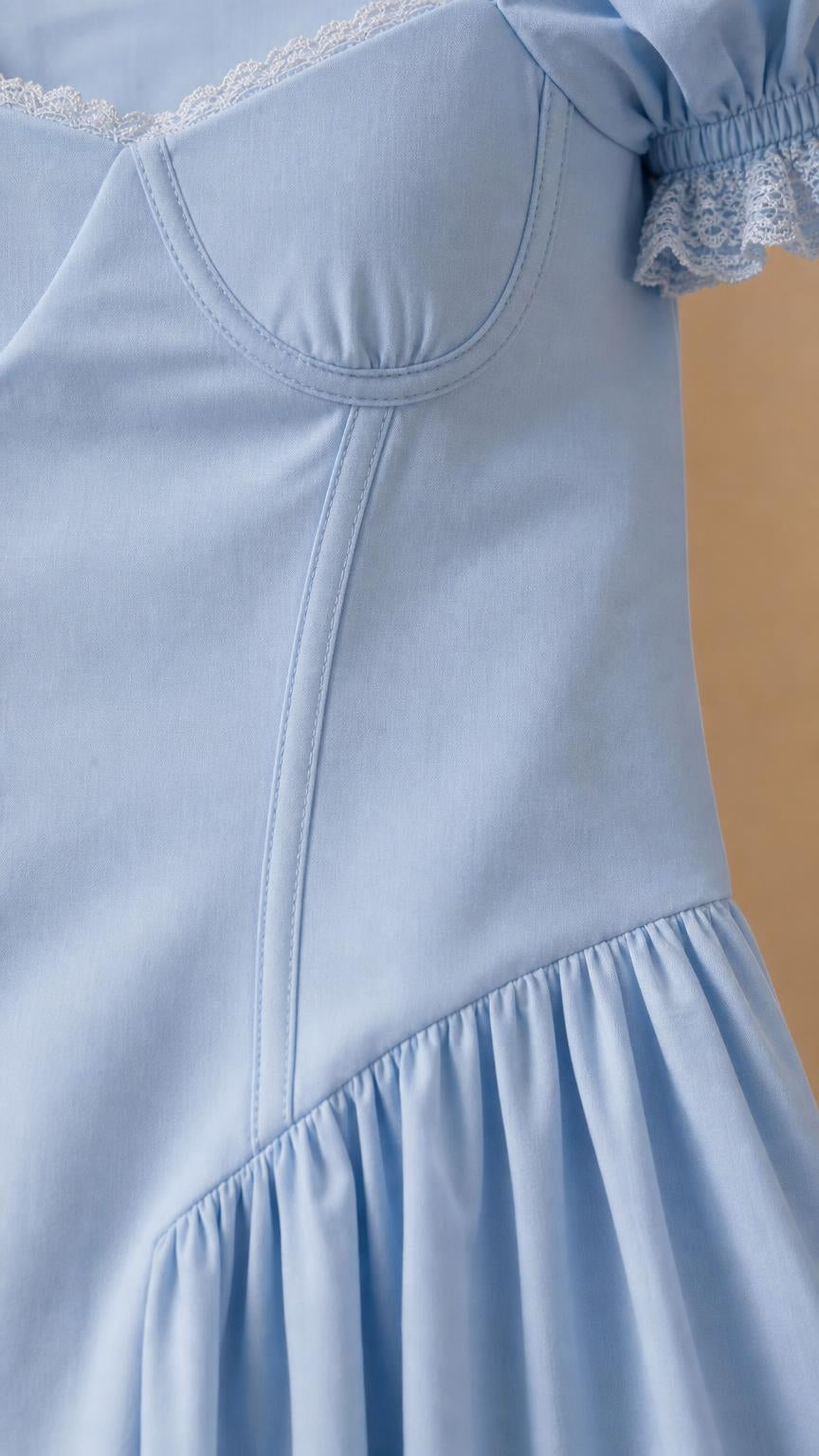 Close-up detail of bodice and lace-trimmed puff sleeve on light blue dress