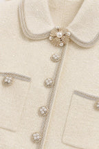 Close-up detail of pearl buttons and collar on tweed dress