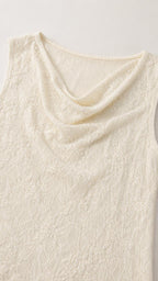 Close-up detail of cream lace fabric and cowl neckline