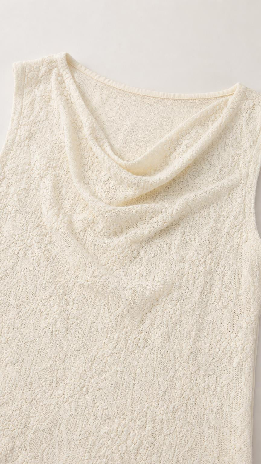 Close-up detail of cream lace fabric and cowl neckline