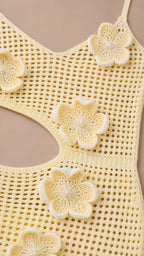 Close-up detail of 3D floral appliques on yellow crochet dress