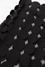 Close-up detail of smooth black circular fabric appliques