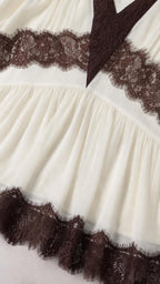 Close-up detail of lace inset and hemline on white dress