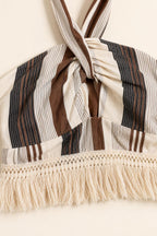 Close-up detail of halter twist and fringe trim on beige stripe dress