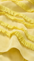 Close-up detail of yellow fabric and fringe tiers