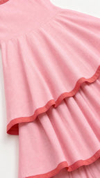 Close up of pink tiered dress ruffles and contrast piping