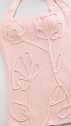 Close-up detail of 3D floral applique texture on pink fabric