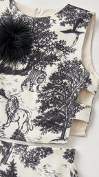 Close-up detail of white and black top showing print and feather applique
