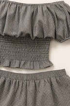 Close-up of ruffled off-the-shoulder neckline and smocked top
