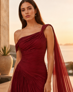 Close-up of wine one-shoulder ruched bodice with sheer shoulder drape detail