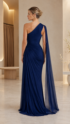 Back view of navy one-shoulder gown showing cape sash