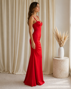 Side view of red satin-look mermaid dress showing fitted waist and flared hem