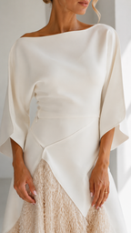 Close-up of ivory boat neck bodice, waist detail, and textured fringe skirt